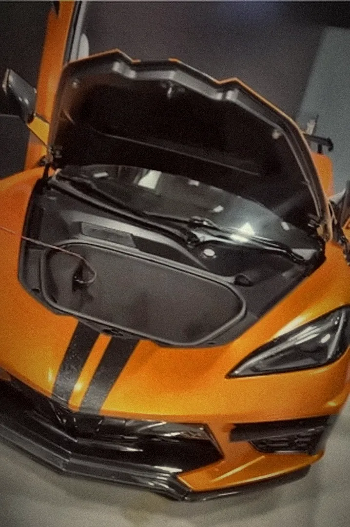 Orange C8 Corvette with the front trunk open inside the Auto Styles shop